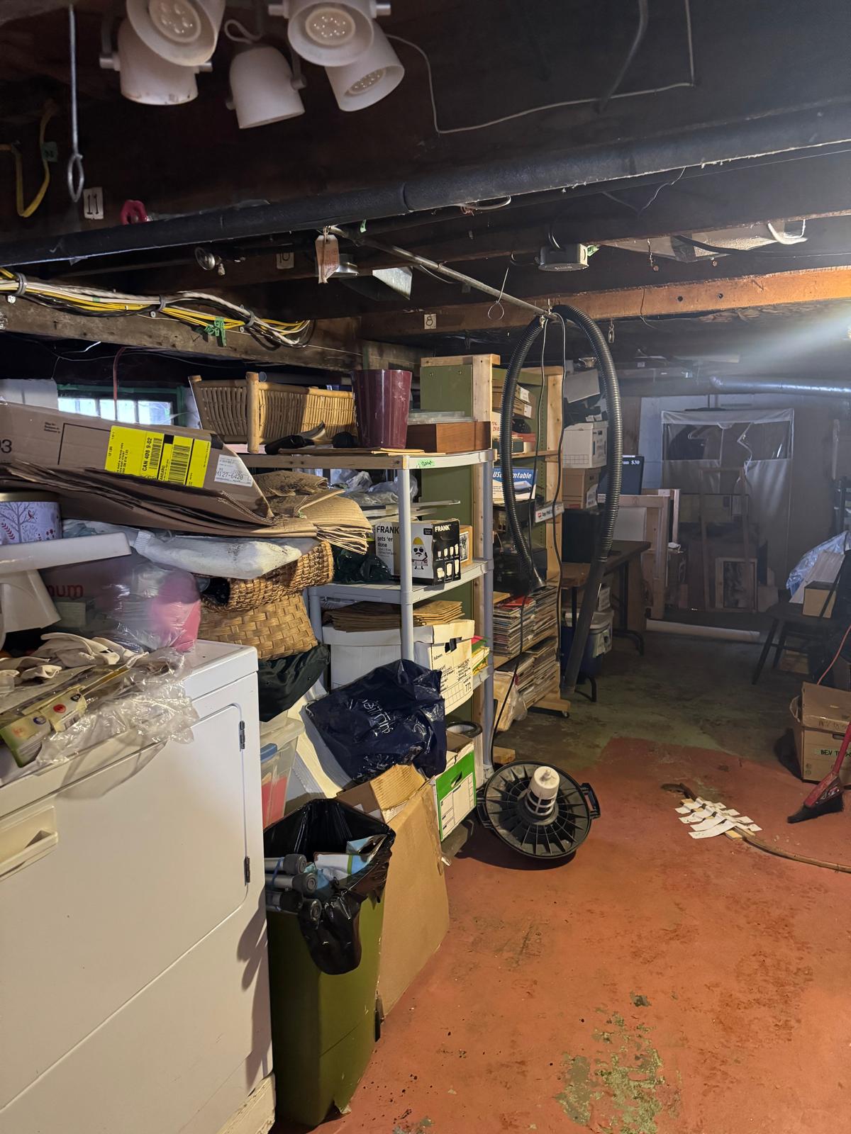 Excess belongings and household items awaiting removal in a basement at one of our listings.