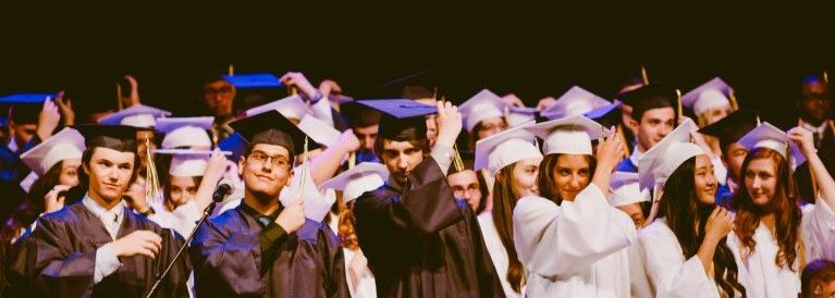 Image of graduating students throwing graduation caps in the air